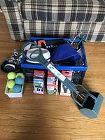 Complete lot showing multiple items including tennis balls, blue spiked balls, poop scooper, dog boots, leash, anchor, food dish, bowl.