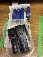 Full lot view showing 4 blue-handled chisels and 2 black Zircon stud sensors in a clear plastic holder.