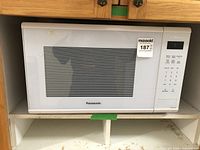 Front view of Panasonic microwave oven showing the door with large window and control panel on the right side.