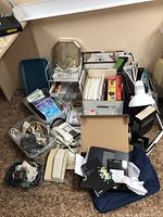 Photo showing the whole bundle with various office electronics and supplies including cables, telephone, power strips, label maker, clock, and organizing trays.