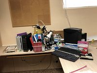Wide view of the office lot items on table, showing shredder, binders, keyboards, and assorted supplies.