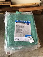 Photo of 9' x 12' polyethylene tarp in green with certification label and Maxsold lot tag.