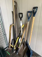 Photo showing entire lot of garden and hand tools grouped in corner
