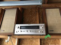 Sony receiver centered, two Sony speakers on either side on wooden shelf