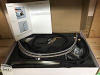 Opened box showing kitchen faucet components including hoses, faucet spout, and installation manual inside foam packaging.