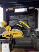 Electric planer in black carrying case showing yellow body, ergonomic handle, and front adjustment knob.