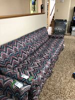 Full view of the zig zag patterned upholstered sofa showing overall condition and pattern detail