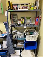 Photo showing a full workshop shelving unit with various items including flashlight, organizers, plastic bins, and miscellaneous hardware