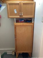 Full view of the pine cabinet with upper cabinet doors closed and lower cabinet door closed, shows overall design and condition.