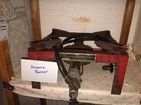 Front view propane burner with hose and valve attached, placed on cloth-covered table.