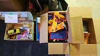 Boxes with assorted toys including toy cars, balls, and children's books.