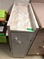 Side view of white tray cabinet with faux marble top and rope handle, showing height and handle detail.