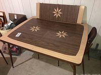 Full view of the vintage dinette table showing woodgrain and starburst inlay.