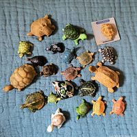 Top-down view of all 20 turtle figurines showing variety in size, material, and color