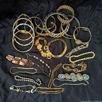 Full lot overview showing the wide variety of bracelets including bangles, cuffs, chain links, beaded, and stone-embellished designs in gold and silver tones.