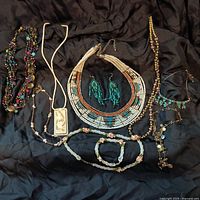 Full lot of assorted beaded jewelry including necklaces, earrings, and bracelets arranged on black fabric