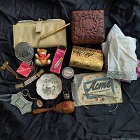 Full view of all items in lot laid out showing sewing kit, darning egg, purses, dime holder, handkerchiefs, eyeglasses and jewelry pieces.