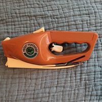 Side view of vintage Pocket Fisherman handheld fishing rod showing logo and handle.