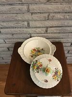 Photo showing open tureen and separate lid with floral decoration and rose handle