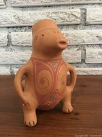 Frontal view of South Western ceramic pottery figure depicting a creature with detailed geometric patterns and open mouth.