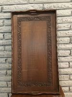 Full top view showing carved floral border and handles on wooden rectangular tray.