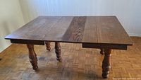 Full view of antique oak dining room table showing the top surface with two leaves extended and wood grain details.