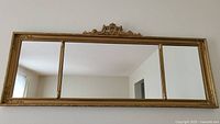 Front view of three-panel mirror in gold ornate frame