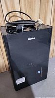 Front view of the black Danby dehumidifier with power cord on top, showing brand logo.