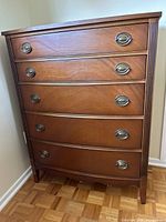 Front view of dresser showing five drawers and oval metal drop handles