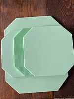 Top view of the four mint green octagonal glass trivets stacked, showing size difference and smooth top surface.