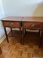 Pair of night stands positioned side by side on parquet floor
