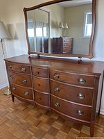 Front view of wooden dresser with attached mirror showing overall style and finish