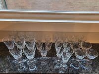 Full collection of 28 vintage Cross and Olive crystal glassware arranged in rows showing different glass types and sizes.