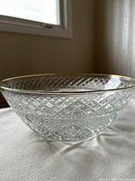 Side angle of clear glass bowl showing diamond-cut pattern and gold rim.