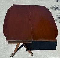 Top view of the mahogany folding card table showing the two hinged panels and wood grain.