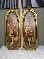 Front view of two vertically oriented goldtone Dart Syroco frames with vintage 1964 still life floral prints by Cecil Rubino, with ruler for scale approx 22.75 inches height.