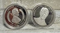 Front side of Abraham Lincoln and Jimmy Carter silver plated commemorative coins showing portraits and inscriptions.