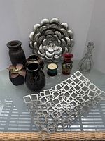 Full view of lot showing nine pieces including Navajo vase by Cedar Mesa, multiple Asian vases, silver metallic flower decor, candle holder, and geometric metal grid.
