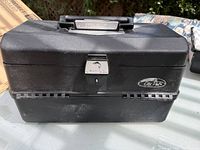 Closed black Old Pal tackle box showing front latch and branded logo plate