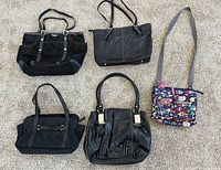 Top view of all five handbags including two black leather Tignanello bags, one vintage black canvas Kate Spade bag, one black canvas Franco Sarto bag, and one colorful Lily Bloom crossbody bag.