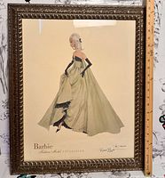Frontal photo of the framed lithograph showing the Barbie figure in a green dress with signature and edition number visible.