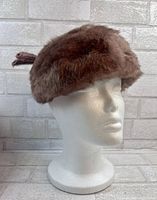 Front and side view of the brown angora pill box hat displayed on a white mannequin head, showing the soft fur texture and overall shape.