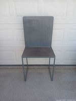 Front view of the arts and crafts table showing the upright back panel and seat surface with metal frame.