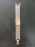 Full view of Bulova wristwatch showing metal wristband with star-shaped designs and rectangular watch face.