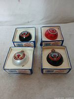 Four vintage Chicago Bulls spherical Christmas ornaments in original boxes, displayed on a white surface.