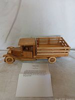 Full side view of the wooden collectible truck showing cabin, truck bed, and wheels.