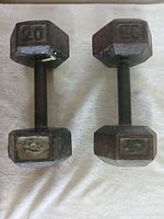 Top view of two 20 lb hex dumbbells side by side on a towel, showing the weight markings and shape