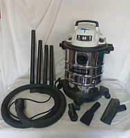 Full view of the Hart shop vac and all included accessories displayed on a white background showing vacuum unit, four extension wands, hose, and three nozzle attachments.