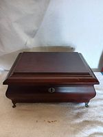 Closed top view of wooden humidor showing smooth surface with slight wear and lock keyhole in front center.