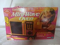 The original box of the Kenner Easy Bake Mini-Wave Oven with colorful graphics and kid using the oven.